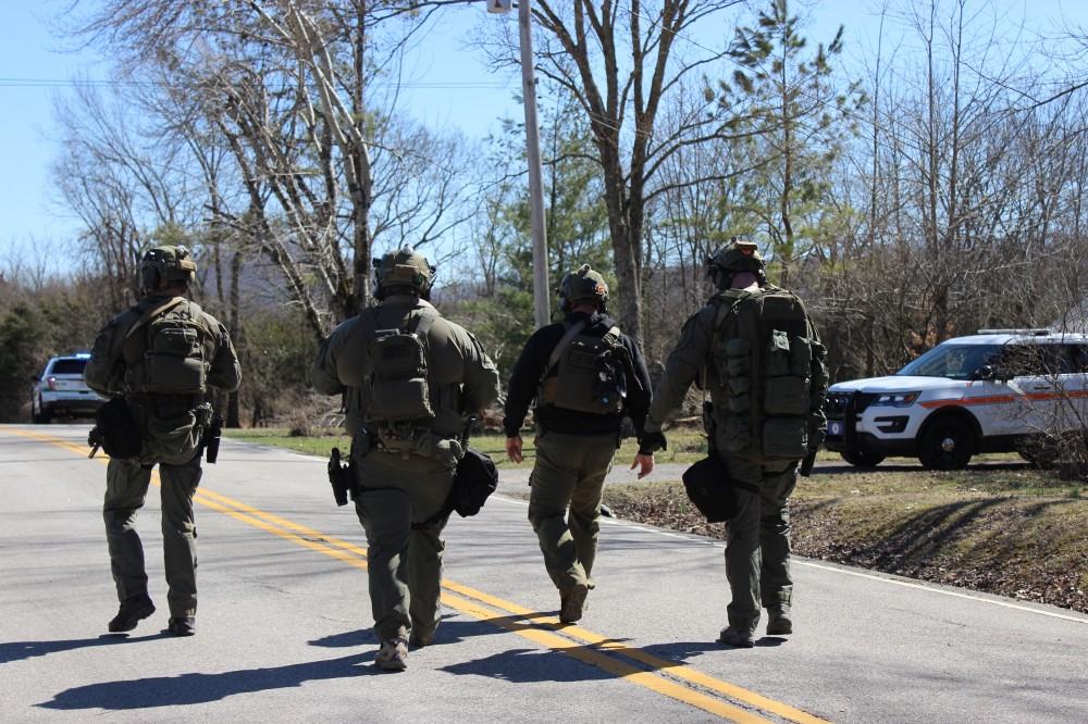 Rutherford County Sheriff’s SWAT Team members walk toward a barricaded suspect’s home Wednesday on Bradyville Pike.